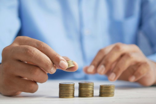 a person stacking coins on top of a table